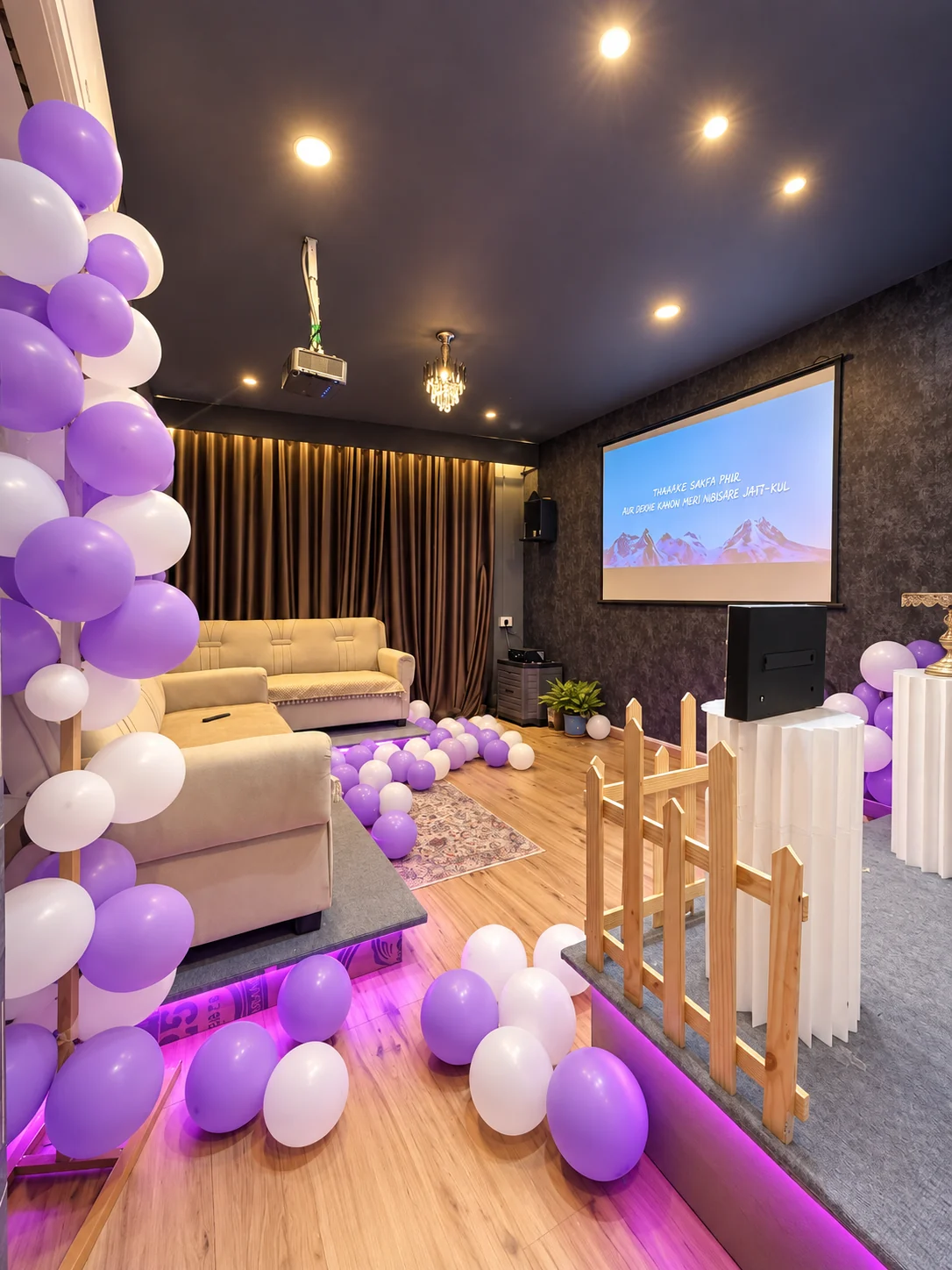 Private projector lounge with purple and white balloons and cream seating